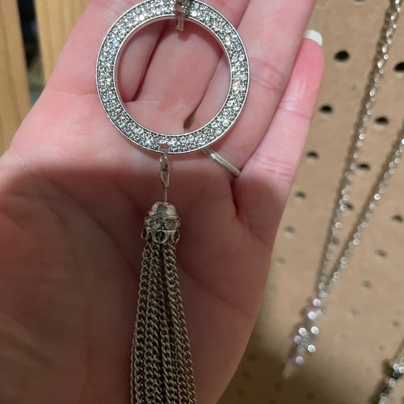 Extra long silver necklace with rhinestone disc and silver chain tassel.